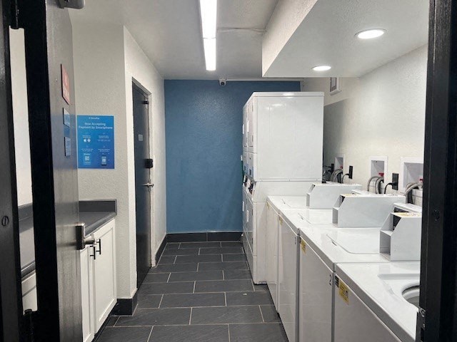 A public restroom with a blue wall and white sinks.