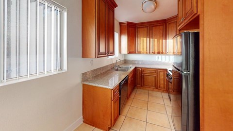 A kitchen with wooden cabinets and a tiled floor.