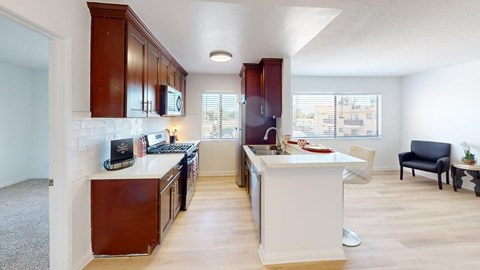 A kitchen with white countertops and wooden cabinets.