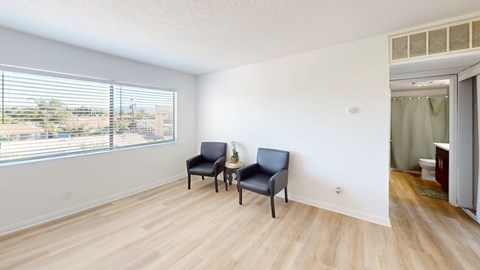 A room with a window and two chairs.