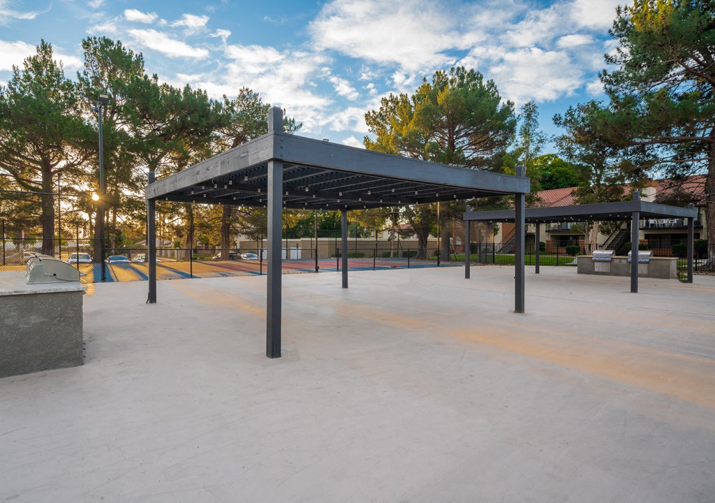a pavilion in a park with trees in the background