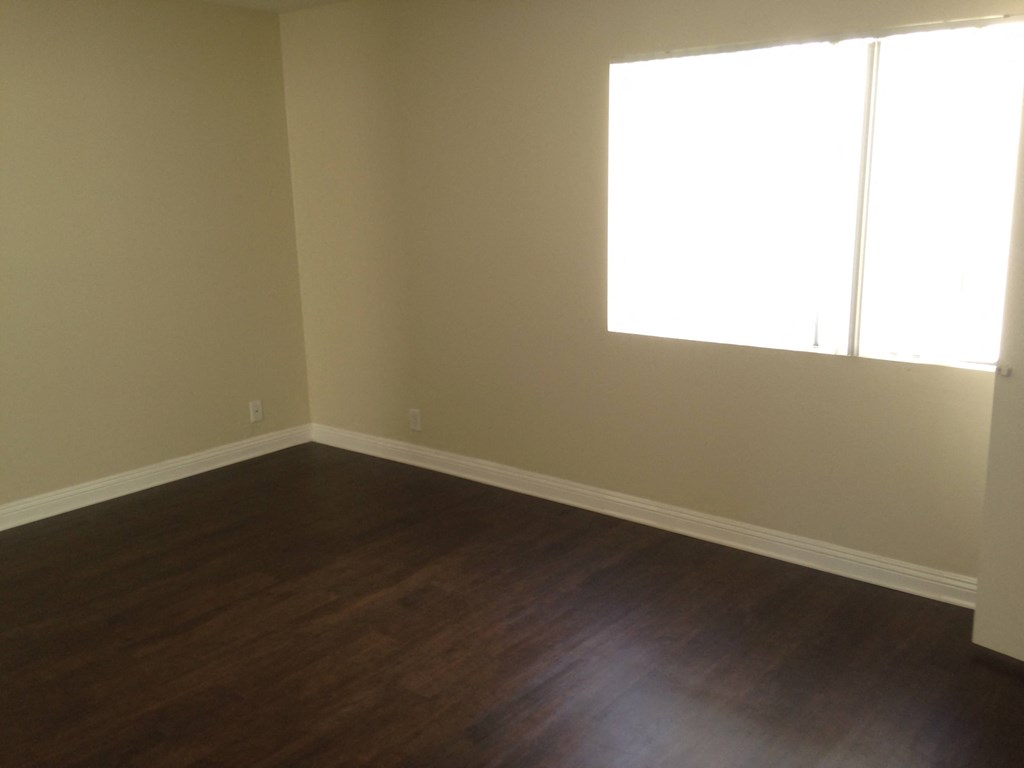A room with wooden floors and a window letting in light.