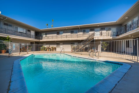 the pool of a hotel with a swimming pool and a building with a staircase