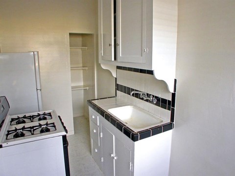 a white kitchen with a stove and a sink