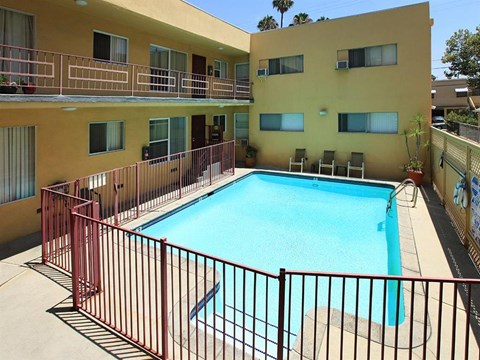 a swimming pool in a building with a fence around it