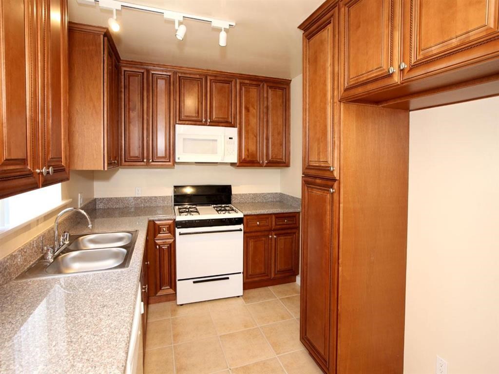 Kitchen with stove, cabinets, and sink