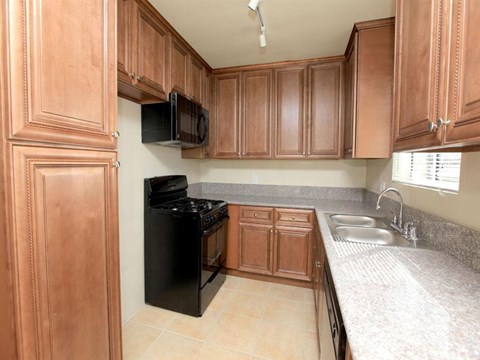 a kitchen with black appliances and wooden cabinets
