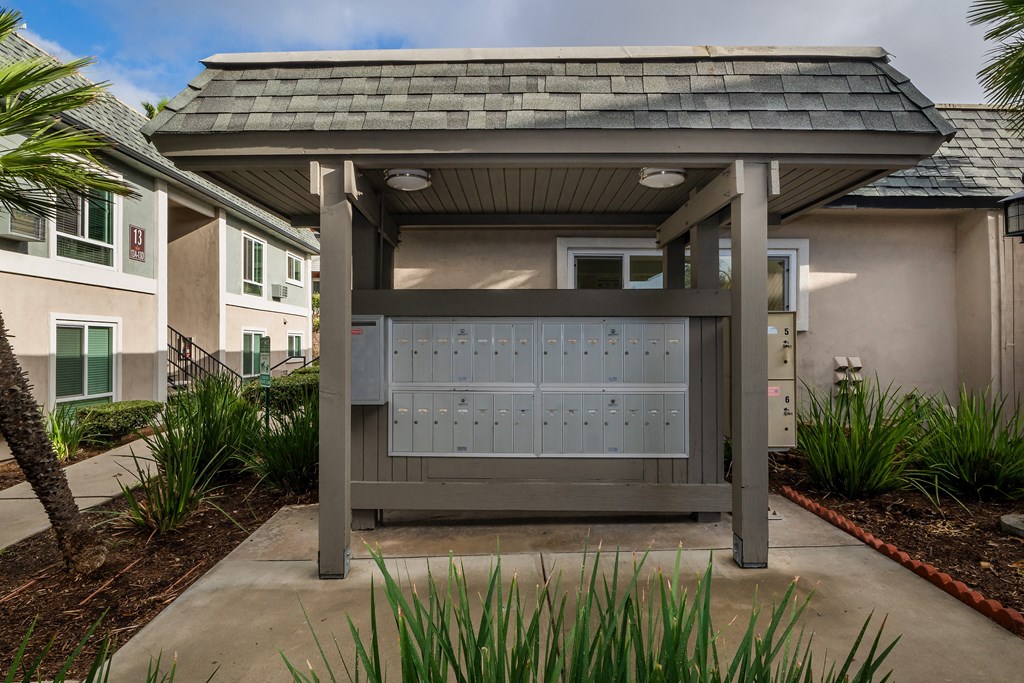 a gate with mailboxes in front of a building