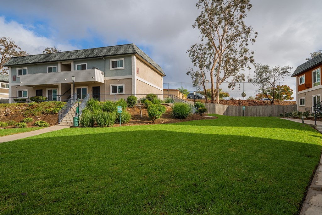 the backyard of a house with a green lawn and a sidewalk