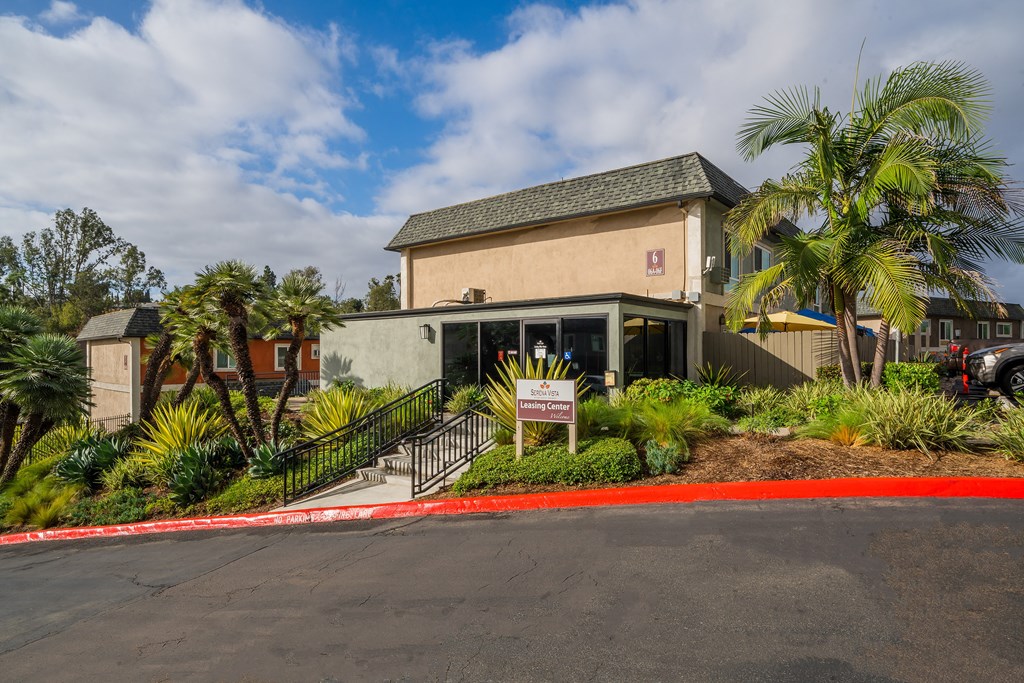 a building with palm trees and a sign in front of it
