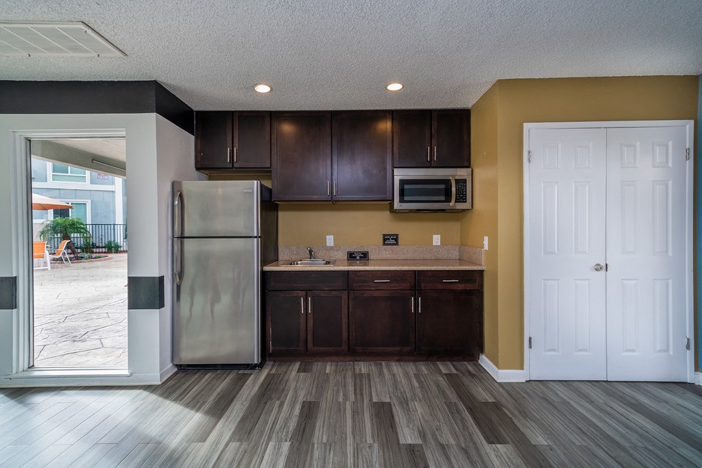 an empty kitchen with stainless steel appliances and wooden cabinets