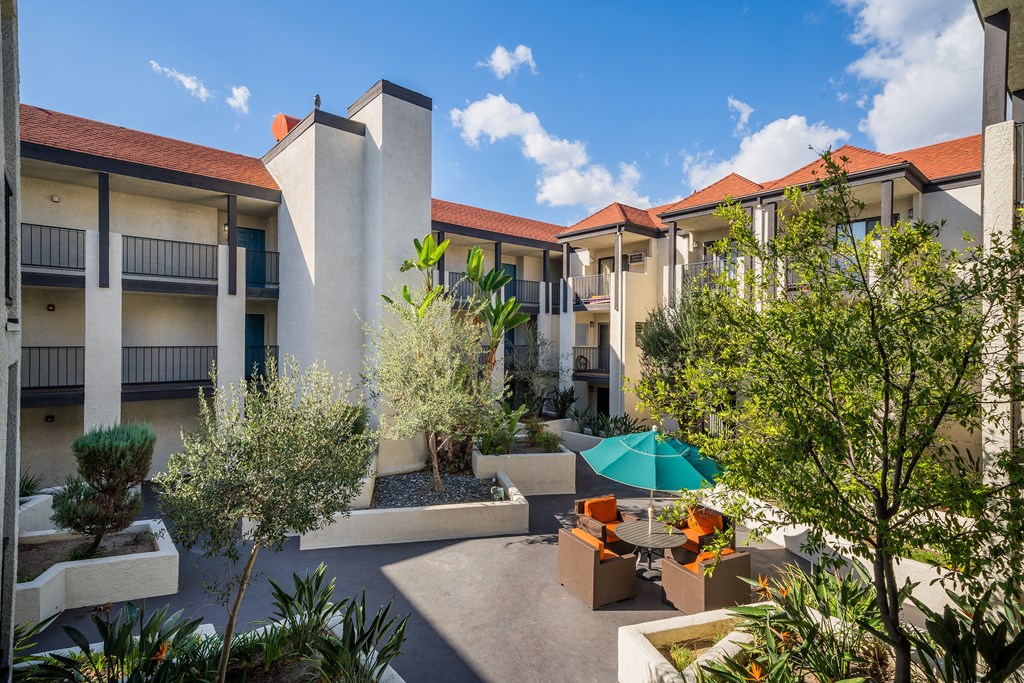a courtyard with tables and umbrellas at the resort