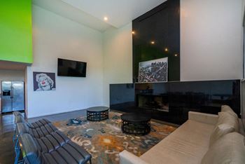 A living room with a fireplace and a TV on the wall.