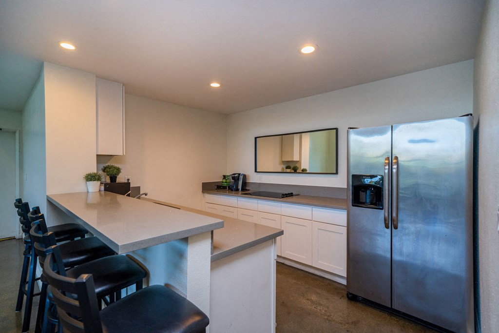 A kitchen with a refrigerator, stove, and counter.