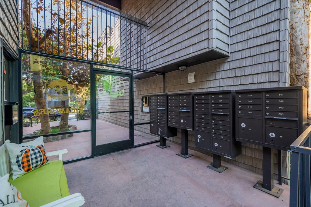 A row of mailboxes are lined up on a wall outside a building.