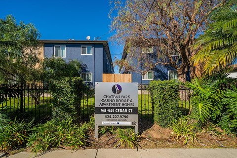 A sign for Chateau Park Casino Royale Apartments is in front of a building.