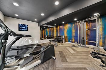 a gym with treadmills and other exercise equipment on the floor and a wall