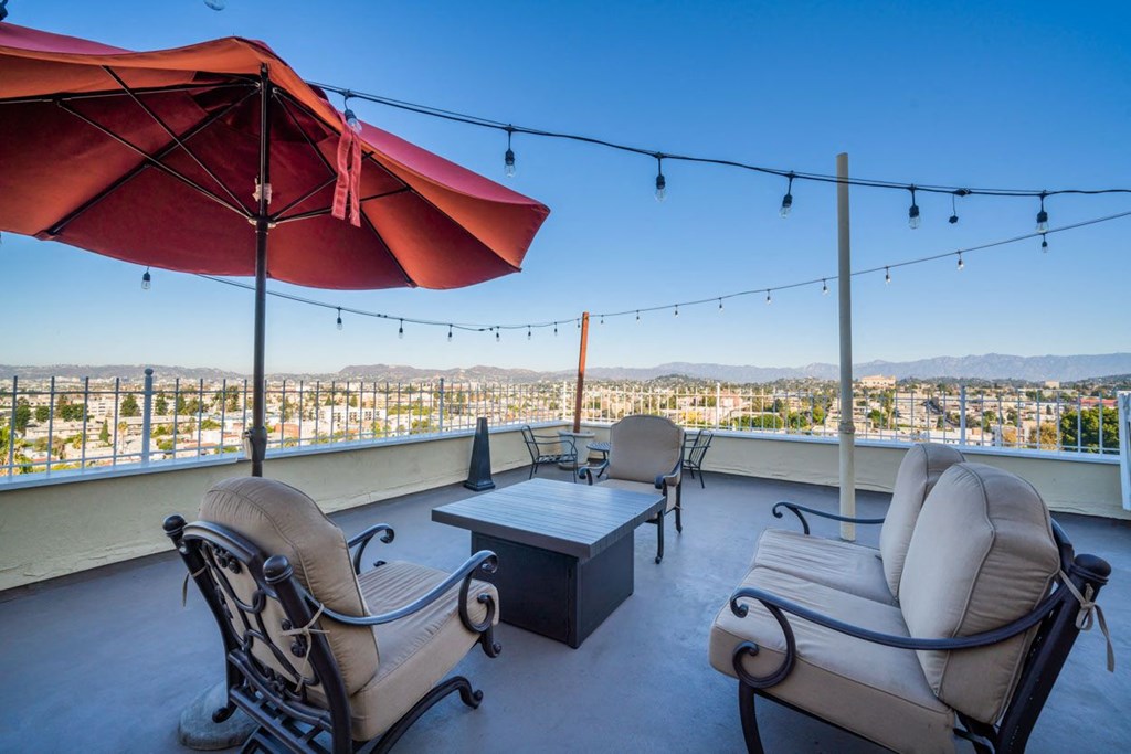 A patio with two chairs and a table with a view of the city.