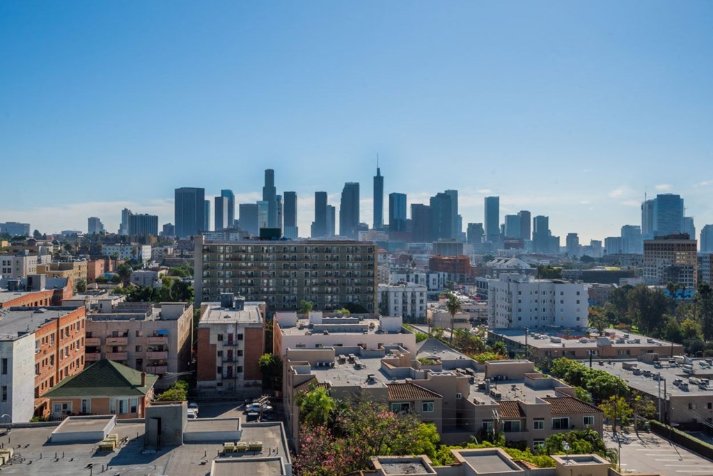 A cityscape with a mix of residential and commercial buildings under a clear sky.