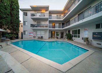 A large swimming pool is surrounded by apartment buildings.