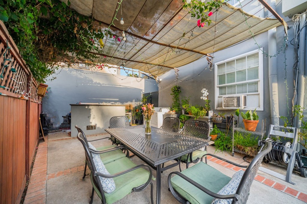 A patio with a table and chairs under a canopy.