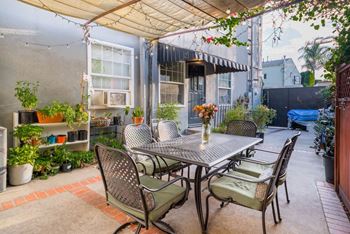 A patio with a table and chairs under a canopy.
