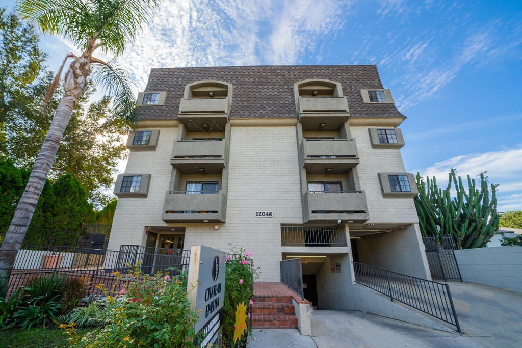 an apartment building with many balconies and a palm tree
