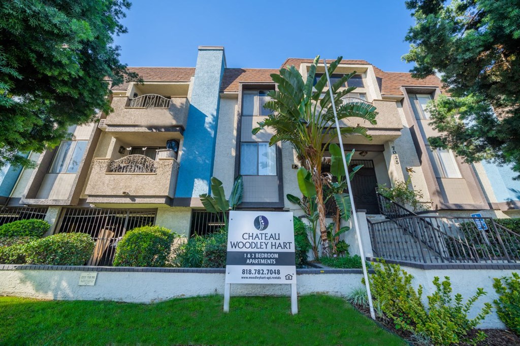 an apartment building with a sign in front of it