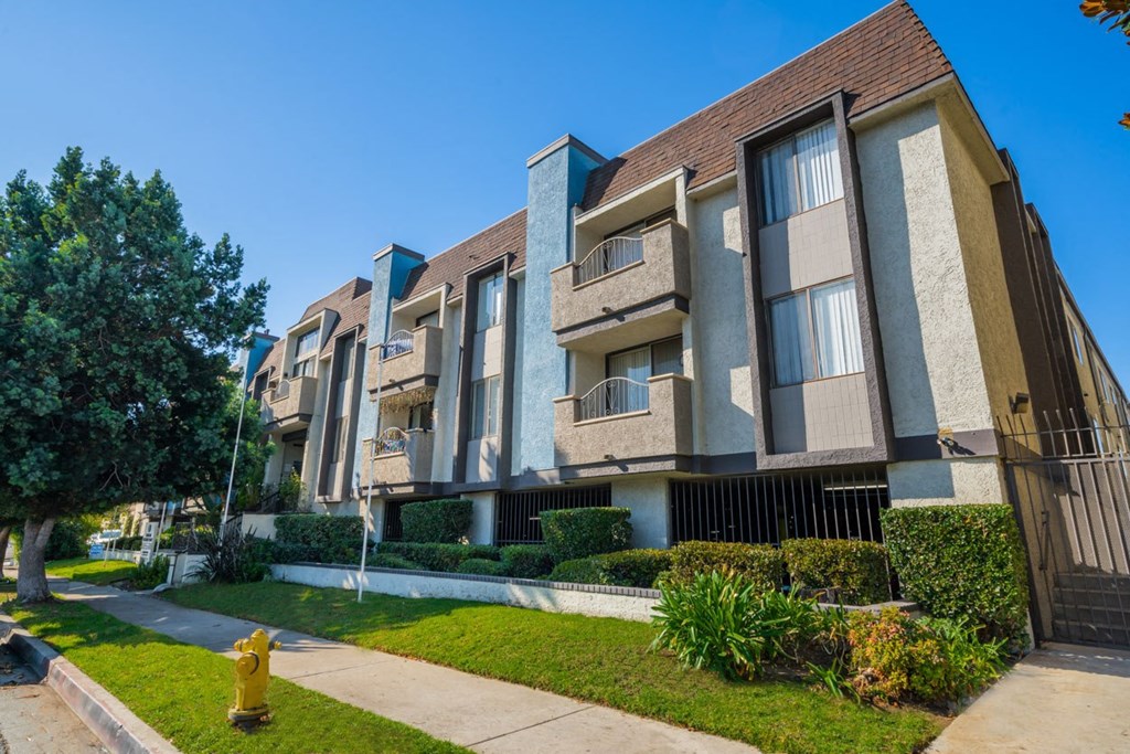 an apartment building with a yellow fire hydrant in front of it