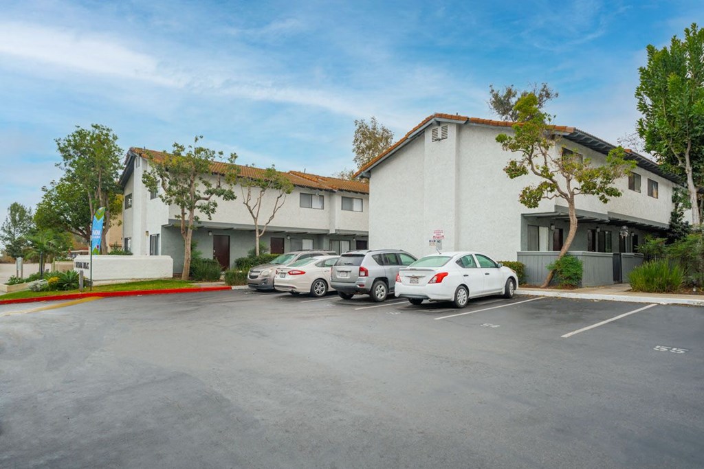 A parking lot with cars and a building in the background.
