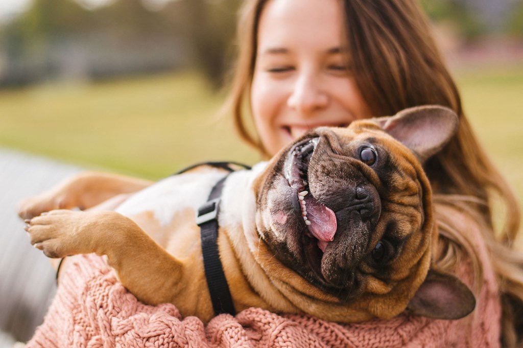 a woman holding a dog in her arms