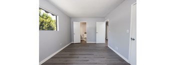 A room with white walls and a window on the left side.