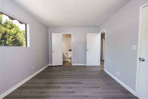 A room with white walls and a window on the left side.