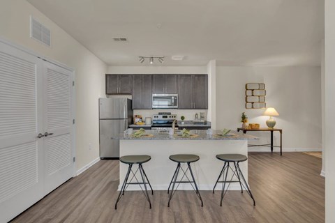 A kitchen with a bar stool in front of a counter.