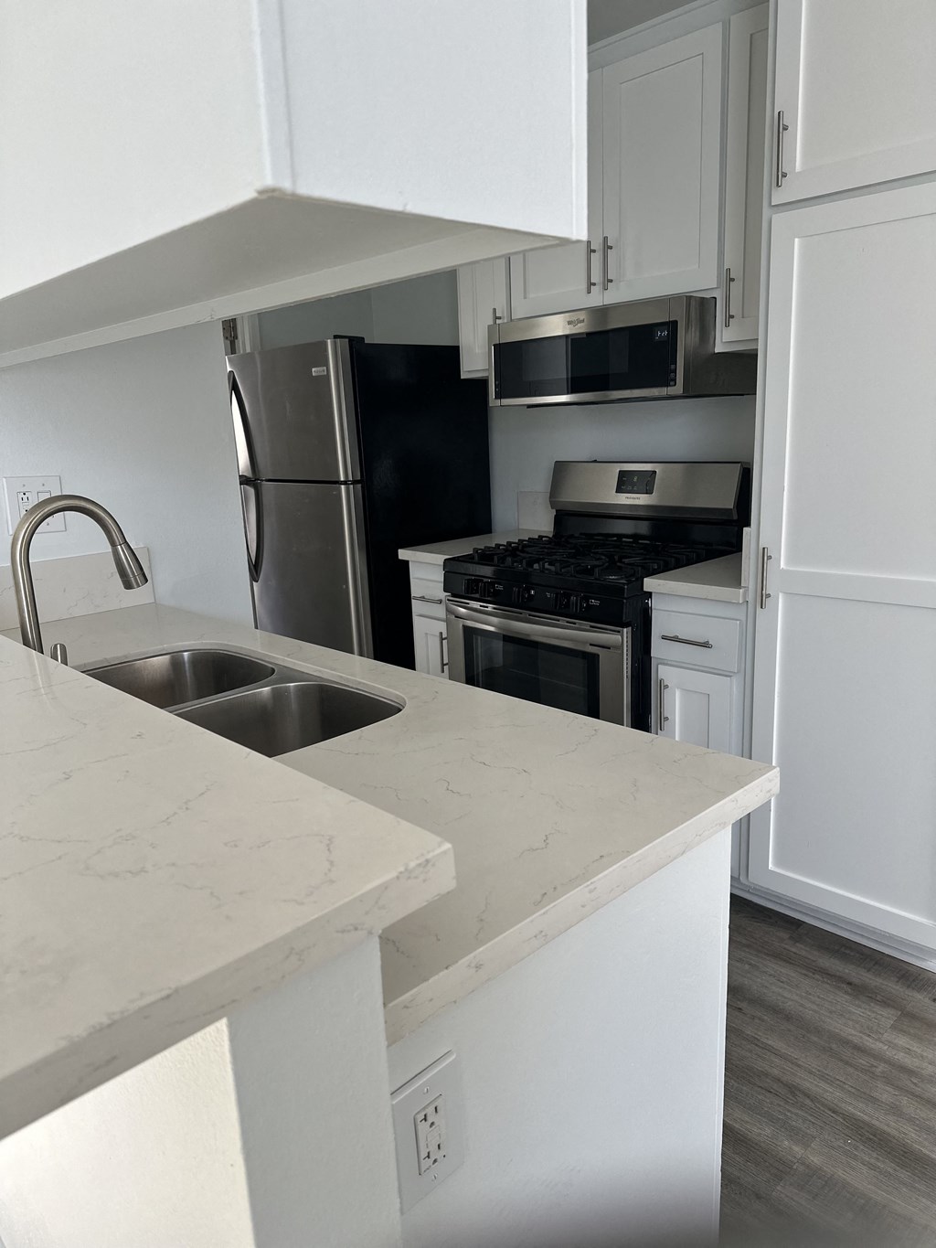 an empty kitchen with white cabinets and a sink