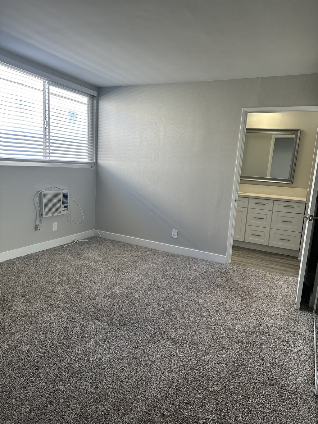 an empty room with carpet and a window