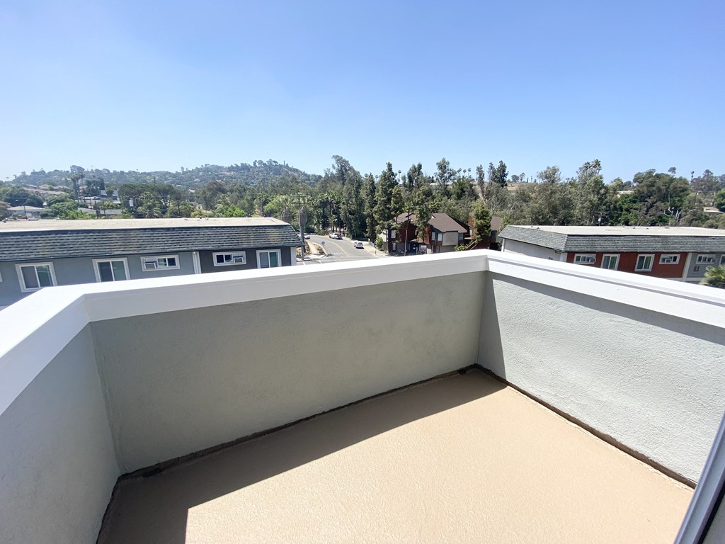 a balcony with a view of a city and a blue sky