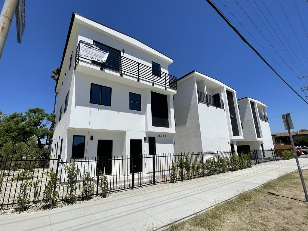 A white building with black railings and windows.