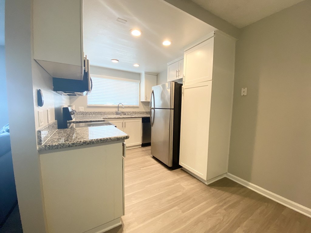 a kitchen with stainless steel appliances and white cabinets and a counter top