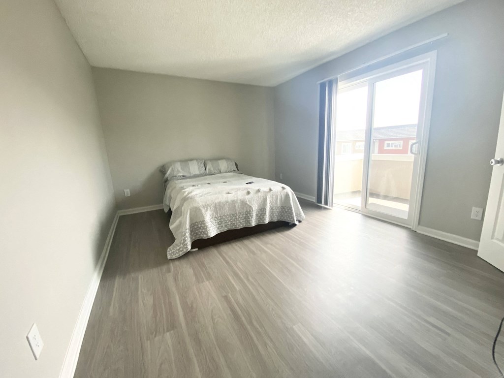 a bedroom with a bed and a sliding glass door
