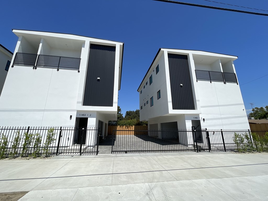 Two white houses with black doors and windows.