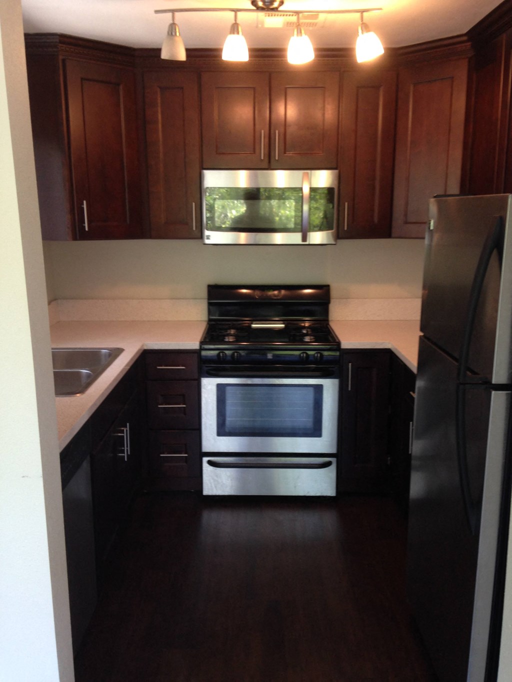 A kitchen with a stove and refrigerator.