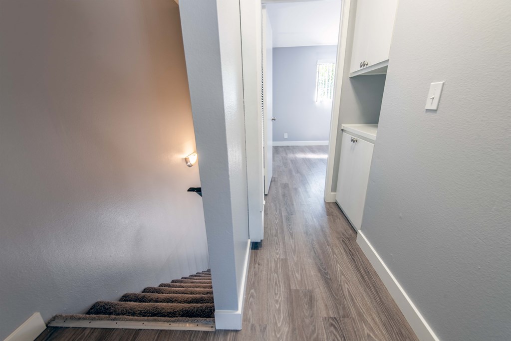 2nd floor hallway with wood flooring and stairwell including pantry at hall