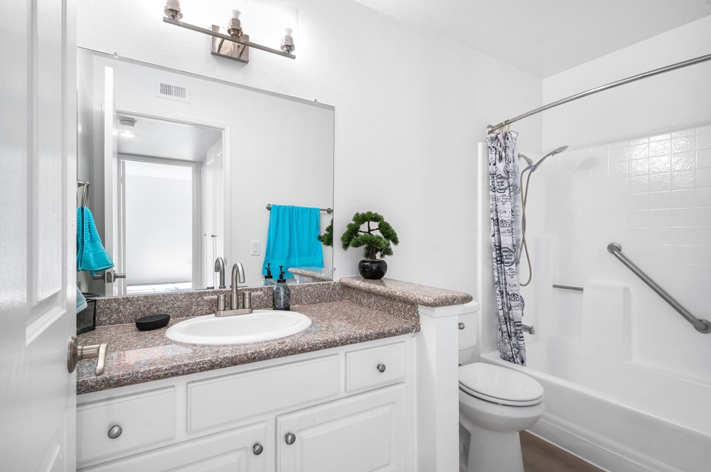 A bathroom with a white sink and a white toilet.