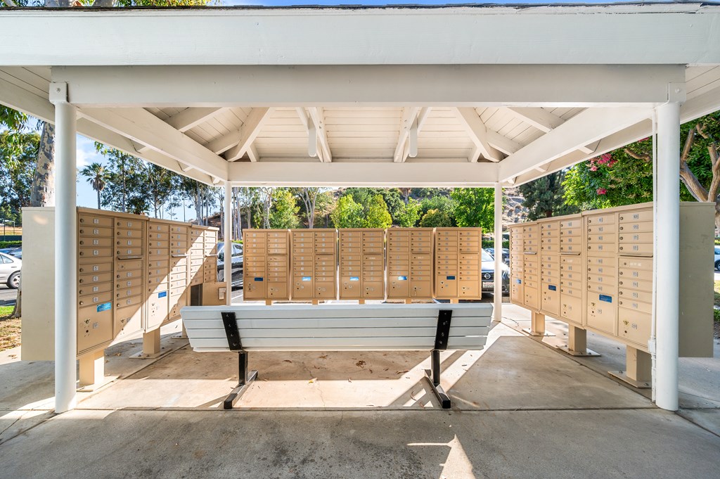 A white covered walkway with a bench in the middle.
