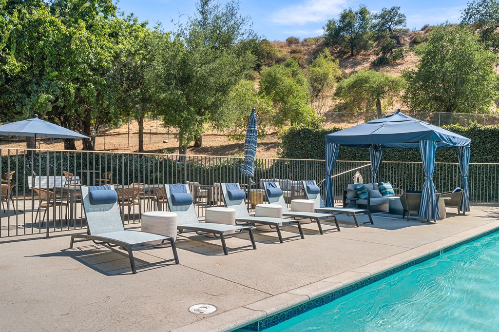 A poolside area with chairs and a gazebo.
