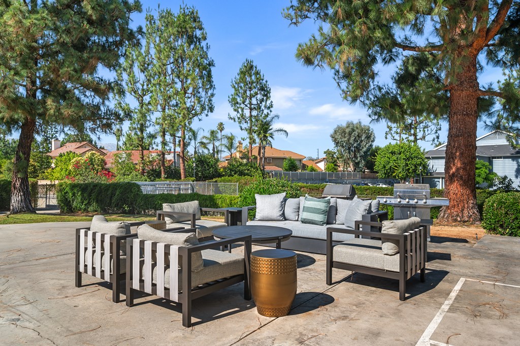 A patio with a table and chairs surrounded by trees.