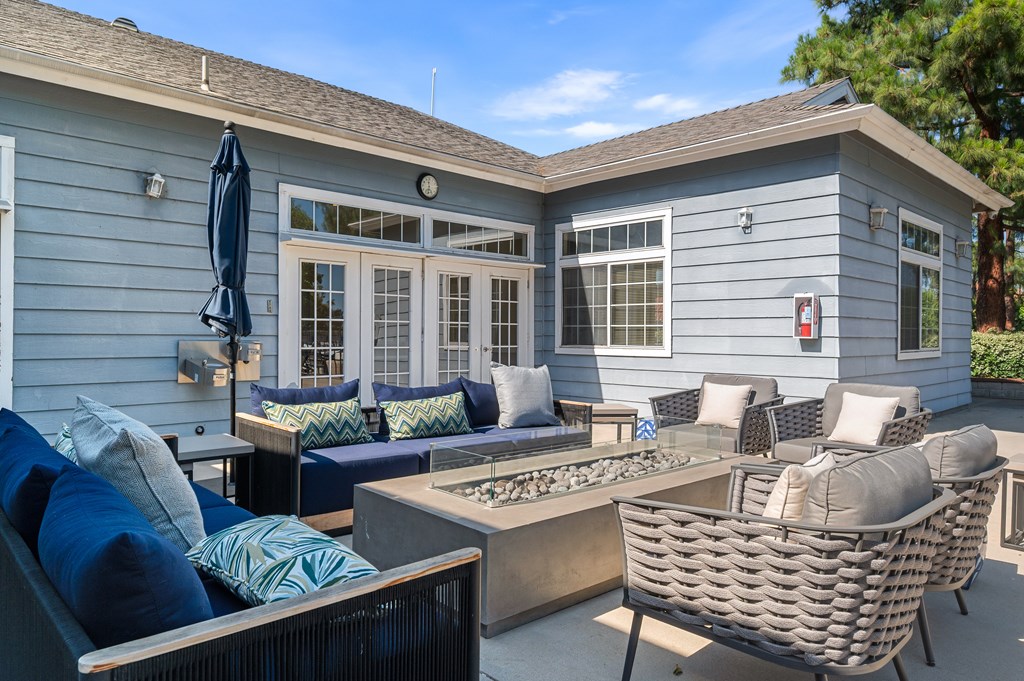 A patio area with  sofa, chairs, and a gas fireplace