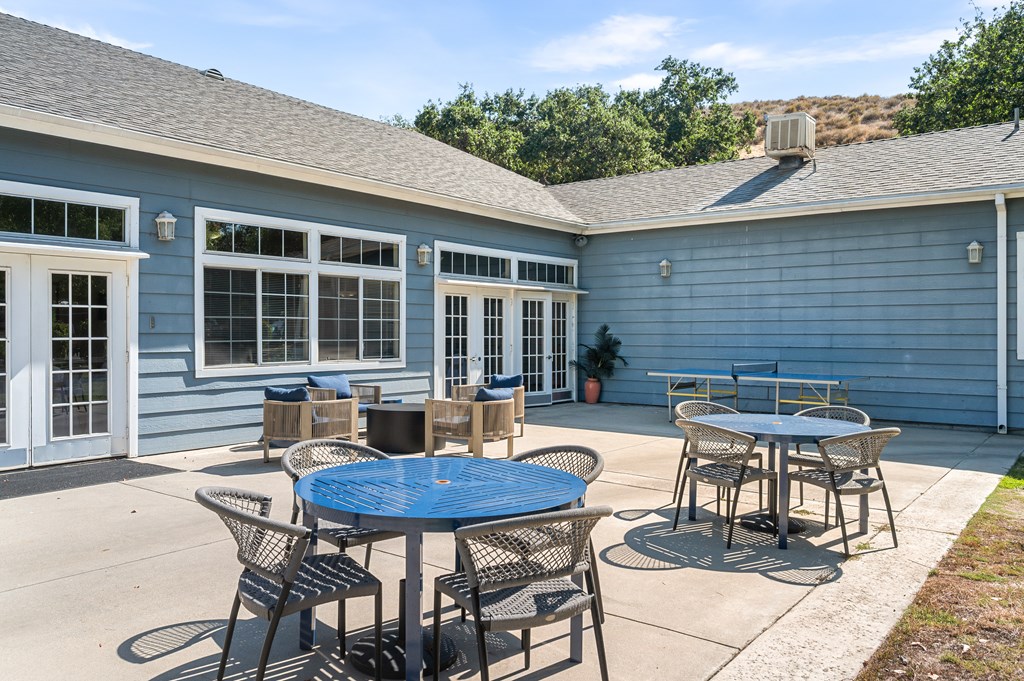 A blue house with a patio and a table.
