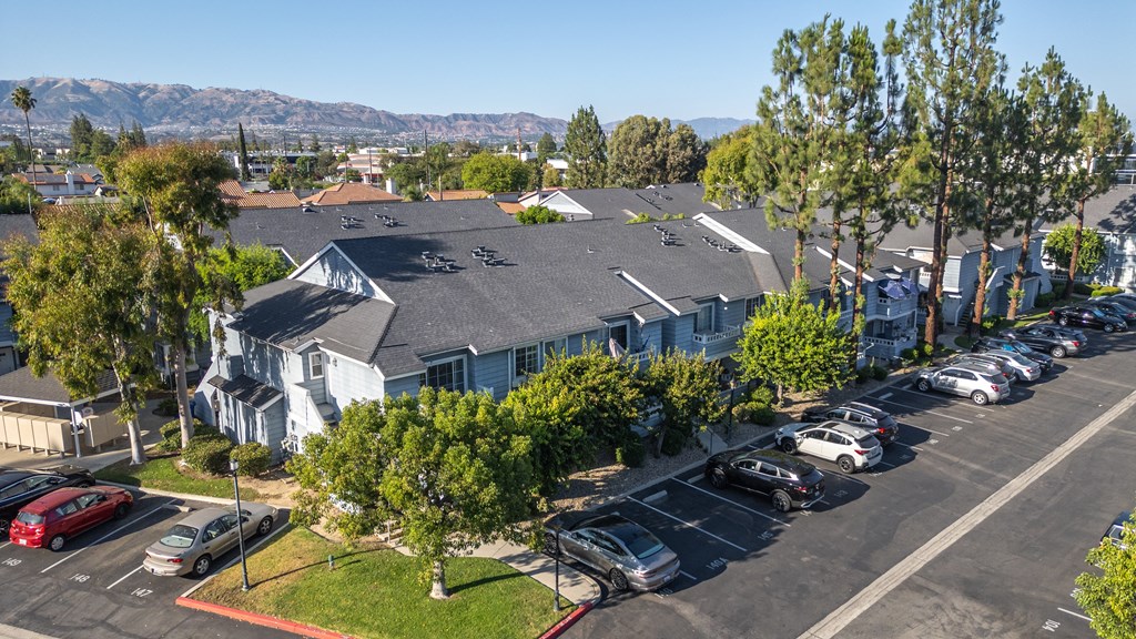A parking lot with cars and a building in the background.